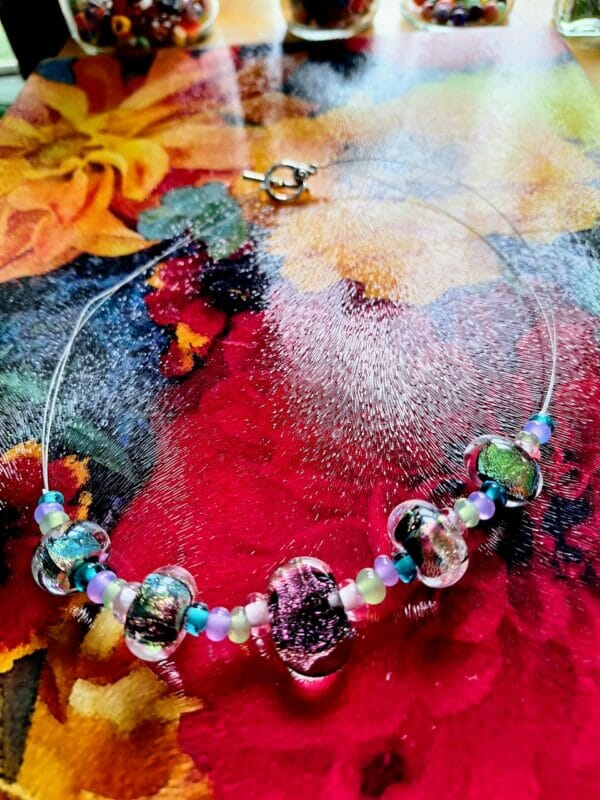 Black dichroic with pinks, greens, blues, and purple necklace